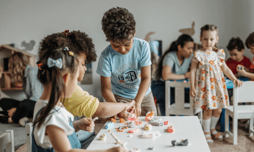 A group of children happily playing with toys in a colorful classroom, promoting learning and teamwork through play.