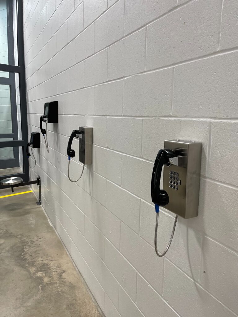 A row of phones mounted on a wall, showcasing various models in a neat and organized arrangement.